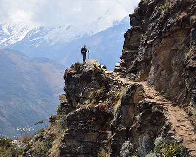 Man resting on the ascent to Choquequirao, in the background snowy mountains are appreciated