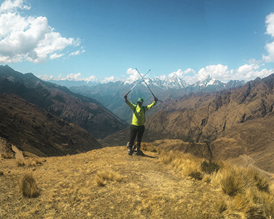 Man with arms raised with mountains background