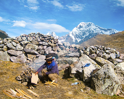 Mountain cook preparing food with a view of Ausangate Mountain