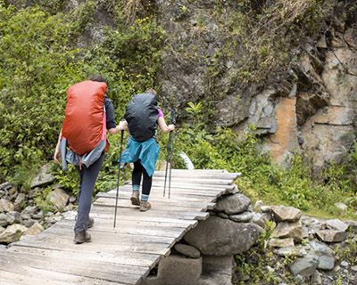 Travelers crossing artisan bridge in Chaullay
